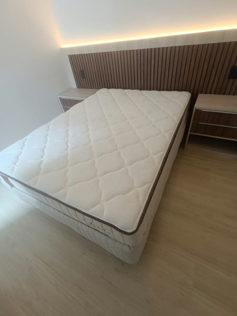 Colchão de casal branco com superfície matelassada sobre cama box, em quarto residencial, em São José dos Campos SP.